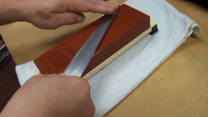 sharpening a knife with whetstone